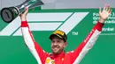Pembalap Ferrari, Sebastian Vettel mengangkat piala penghargaan usai menjuarai F1 GP di Montreal, Kanada, Minggu (10/6). Vettel menyudahi balapan di posisi terdepan dengan catatan waktu 1 jam 28 menit 31,377 detik. (Ryan Remiorz/The Canadian Press via AP)