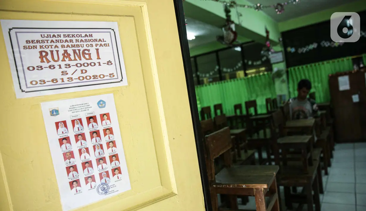 Petugas marapikan bangku di SD Negeri Kota Bambu 03/04, Jakarta, Sabtu (21/11/2020). Pemerintah pusat memberikan kewenangan pemerintah daerah membuka sekolah dan melakukan pembelajaran tatap muka pada semester genap tahun ajaran 2020/2021. (Liputan6.com/Faizal Fanani)