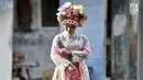 Seorang gadis bersiap mengikuti upacara adat Ngarot di Desa Lelea, Indramayu, Jawa Barat, Rabu (19/12). Tradisi Ngarot merupakan bentuk doa masyarakat Desa Lelea agar hasil tanam padi selalu subur. (Merdeka.com/Iqbal Nugroho)
