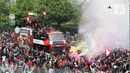 Suara petasan dan flare dinyalakan para pendukung saat kedatangan pemain Timnas U-22 Indonesia yang menaiki bus tingkat Transjakarta. (Liputan6.com/Herman Zakharia)