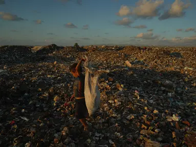 Seorang anak Palestina yang mengungsi mencari kayu bakar dan plastik di tempat pembuangan sampah di samping kamp tenda darurat tempat keluarganya berlindung, di Khan Younis, Jalur Gaza selatan, Selasa 30 September 2025. (AP Photo/Jehad Alshrafi)