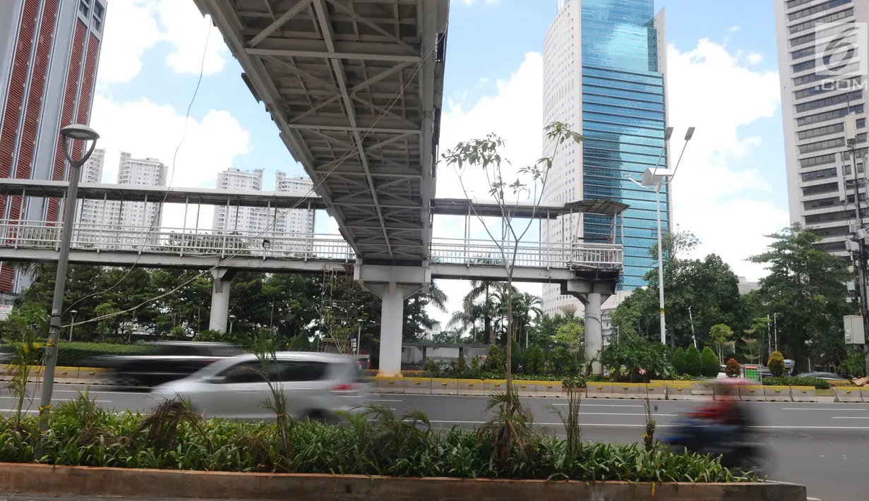 Kendaraan melintas di Jalan Jenderal Sudirman, Jakarta, Jumat (4/1). Jembatan penyeberangan orang (JPO) Dukuh Atas ini menggantikan JPO lama yang membentang tepat di tengah Jalan Jenderal Sudirman. (Liputan6.com/Herman Zakharia)