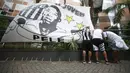 Penggemar memasang bendera dengan gambar legenda sepak bola Brasil Pele saat berjaga di luar pintu masuk Rumah Sakit Albert Einstein di Sao Paulo, Minggu (4/12/2022). Pele, telah dilarikan ke rmah sakit sejak hari Selasa, 29 November 2022 kemarin. (Photo by Miguel Schincariol / AFP)