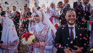 Pasangan Palestina berpartisipasi dalam upacara pernikahan massal di Kota Hamad, Khan Younis, Jalur Gaza, Selasa 2 Desember 2025. 54 pasangan muda Palestina di Gaza melangsungkan pernikahan massal pada Selasa (2/12/2025). (AP Photo/Abdel Kareem Hana)