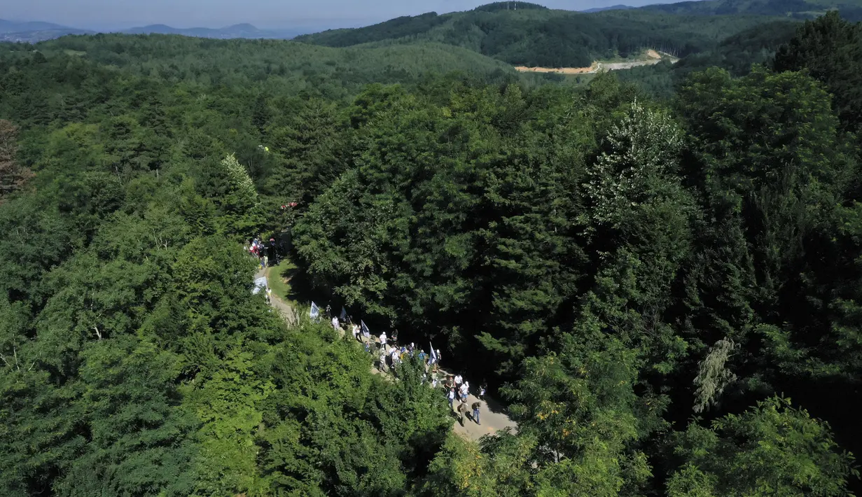 Rakyat Bosnia berjalan melalui daerah pegunungan dekat Crni Vrh saat memperingati 25 tahun pembantaian Srebrenica di Bosnia, Rabu (8/7/2020). Acara yang diikuti beberapa korban selamat dari pembantaian tersebut mengambil rute saat mereka melarikan diri dari pasukan Serbia. (AP Photo/Kemal Softic)