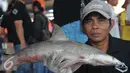 Nelayan memperlihatkan ikan hiu di tempat pelelangan ikan, Karangsong, Indramayu, Jawa Barat, Kamis (16/6/2015). Meski sudah ada larangan perburuan dan perdagangan, nelayan setempat masih memperdagangkan sirip hiu. (Liputan6.com/Herman Zakharia)