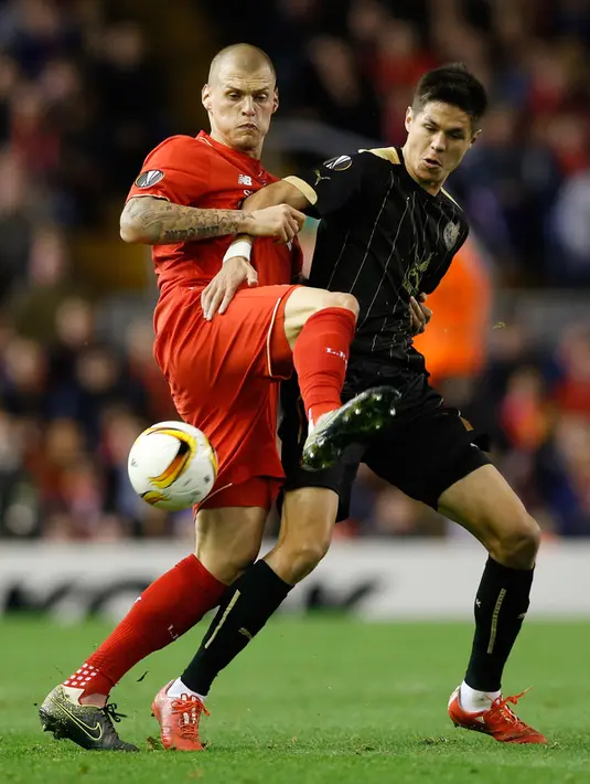 Bek Liverpool, Martin Skrtel (kiri) berusaha mengahalau bola penyerang  Rubin Kazan, Igor Portnyagin pada  laga lanjutan Grup B Liga Europa di Anfield, Jumat (23/10/2015). Liverpool bermain imbang dengan Rubin Kazan dengan skor 1-1. (Reuters/Carl Recine)