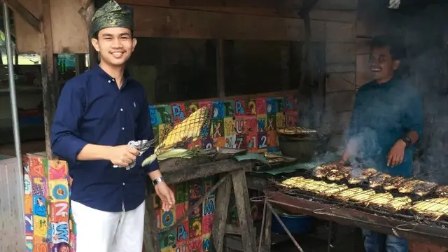 Pemilik warung makan di Kabupaten Kampar tengah membakar ikan kopiek tak bertulang.