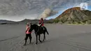 Pemilik kuda mengantarkan pengunjung berkuda di lautan pasir Gunung Bromo, Probolinggo, Jawa Timur, Jumat (10/9/2021). Balai Besar Taman Nasional Bromo Tengger Semeru (BB-TNBTS) mulai membuka pintu masuk kawasan wisata Bromo melalui Kabupaten Probolinggo. (merdeka.com/Arie Basuki)