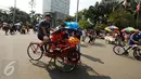 Seorang Warga Negara Asing mengendarai becak saat Hari Bebas Kendaraan di Kawasan Bundaran HI, Minggu (7/5). Ia juga terlihat membawa sepeda anak-anak yang diletakkan di sisi becaknya. (Liputan6.com/Helmi Fithriansyah)
