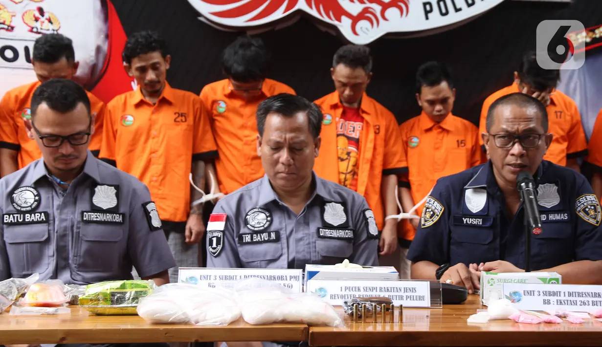 Kabid Humas Polda Metro Jaya Kombes Pol Yusri Yunus (kanan) memberi keterangan saat rilis kasus narkoba jaringan lapas di Ditresnarkoba Polda Metro Jaya, Jakarta, Minggu (22/12/2019). Polisi mengamankan senjata api rakitan dengan 6 peluru dari sembilan orang tersangka. (Liputan6.com/Herman Zakharia)