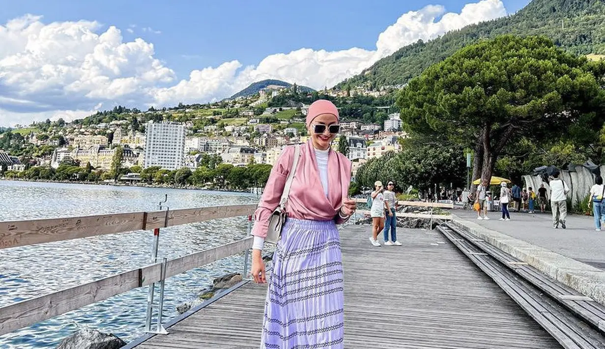 Ayu Maulida kini tinggal di Swiss, ia pun tampil berhijab dengan model turban warna pink serasi dengan atasan kemejanya. Dipadukan rok panjang putih bermotif. [Instagram/@ayumaulida97]