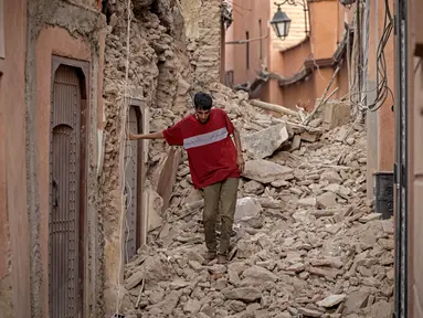 Seorang warga berjalan di antara reruntuhan bangunan setelah gempa berkekuatan 6,8 SR di Marrakesh, Maroko, Sabtu (9/9/2023). (Photo by FADEL SENNA / AFP)