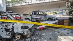 Dua unit mobil polisi usai dibakar massa aksi  unjuk rasa di pos polisi fly over simpang Tomang, Jakarta, Kamis (26/9/2019). Selain menghanguskan pos polisi, api juga membakar belasan sepeda motor dan dua unit mobil polisi yang tengah terparkir di area pos pol Tomang. (Liputan6.com/Faizal Fanani)