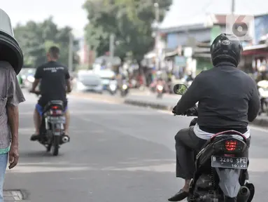 Pedagang tanpa mengenakan masker saat melintas di kawasan Pasar Minggu, Jakarta, Rabu (8/4/2020). Organisasi Kesehatan Dunia (WHO) telah merekomendasikan agar siapa saja menggunakan masker saat berada di tempat umum demi memutus mata rantai penyebaran virus Corona. (merdeka.com/Iqbal Nugroho)