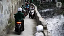Sejumlah pengendara sepeda motor melintasi jalur alternatif di belakang Kompleks Patra Jasa, Jakarta Selatan, Rabu (1/3/2023). Jalur alternatif seperti gang, jalan kecil, maupun jalan tembusan menjadi pilihan bagi pengendara sepeda motor untuk menghindari kemacetan di jalan-jalan protokol Ibu Kota. (Liputan6.com/Johan Tallo)