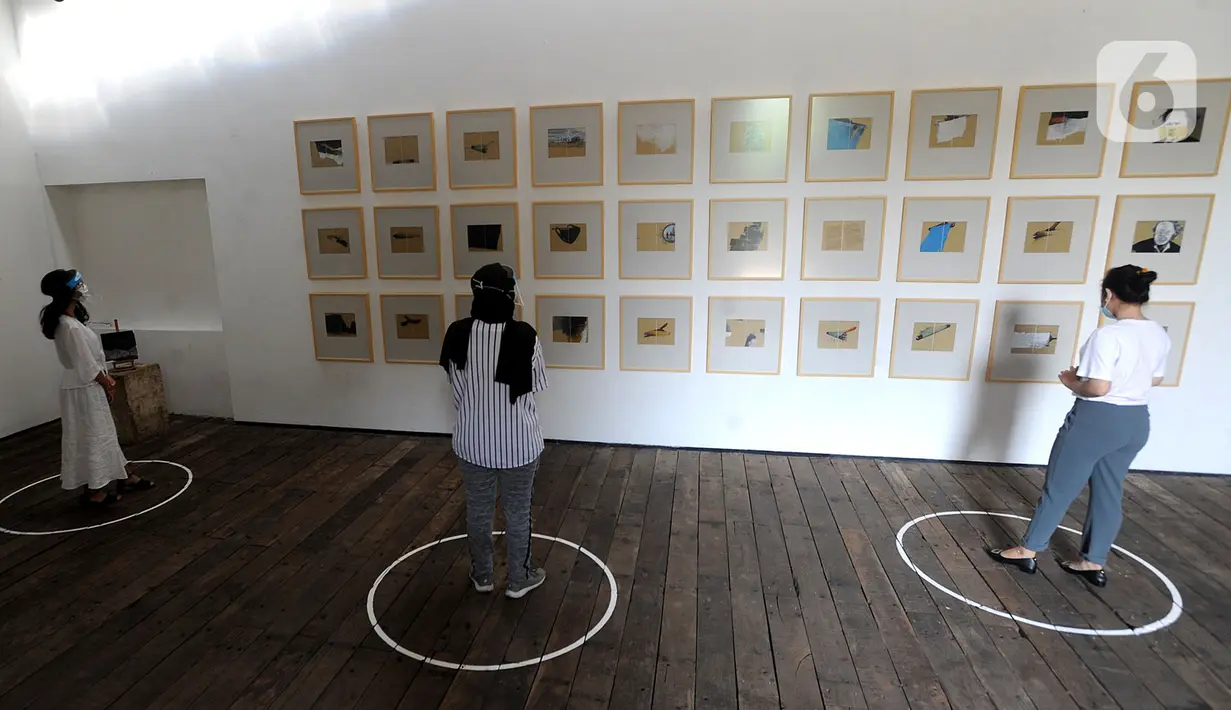 Pengunjung berjaga jarak fisik saat melihat pameran karya pelukis Hanafi berjudul 60 tahun dalam studio di Galerikertas, Depok, Jawa Barat, Selasa (7/7/2020).  Pameran tersebut menerapkan protokol kesehatan guna mencegah penyebaran COVID-19. (merdeka.com/Arie Basuki)
