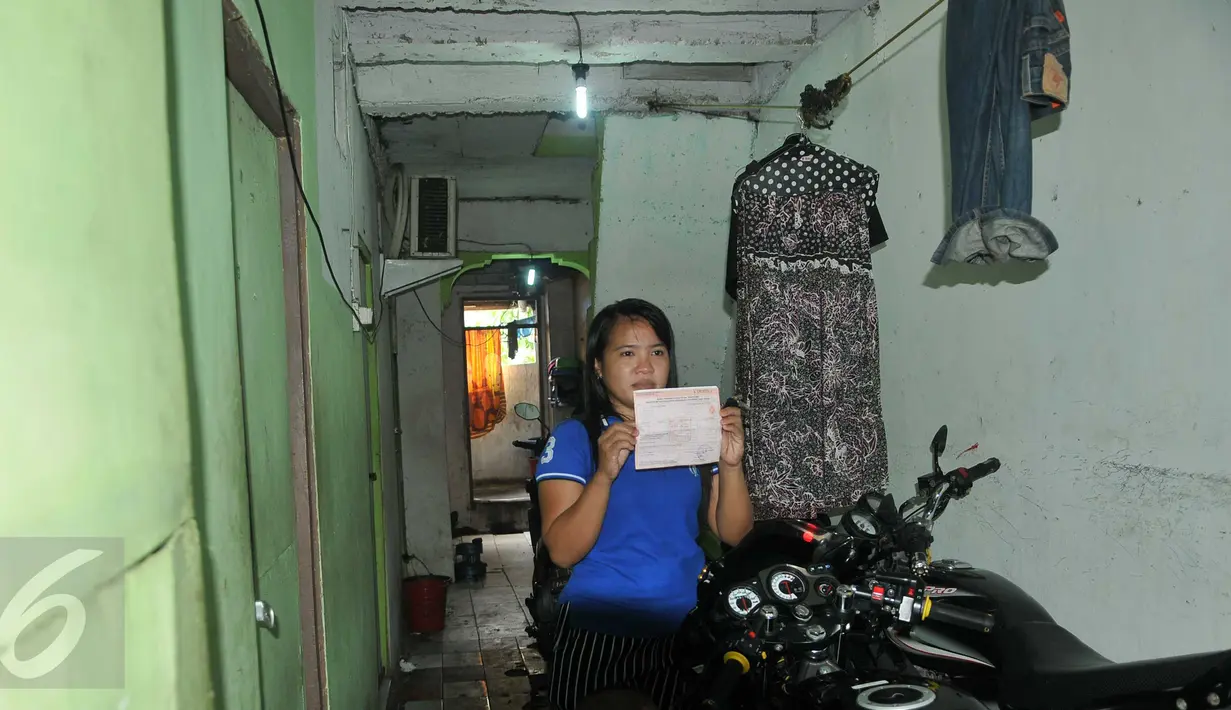 Warga menunjukkan bukti pembayaran PBB rumah miliknya yang akan dibongkar di kawasan Kalijodo, Jakarta, Kamis (18/2). Gubernur DKI hari ini mengirim SP 1 kepada warga untuk mengosongkan dan membongkar sendiri rumah mereka (Liputan6.com/Gempur M Surya)