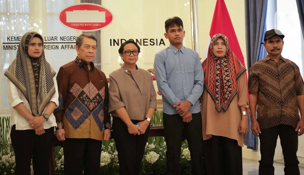 Menlu Retno Marsudi foto bersama dengan Muhammad Farhan, WNI yang disandera kelompok Abu Sayyaf bersama keluarga saat dipertemukan di Kantor Kemenlu, Jakarta, Kamis (23/1/2020). (Liputan6.com/Faizal Fanani)