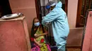 Seorang petugas kesehatan tentara (kanan) menyuntik seorang wanita dengan dosis virus corona COVID-19 saat vaksinasi keliling di Kolombo Sri Lanka, Kamis (12/8/2021). (Ishara S. KODIKARA/AFP)