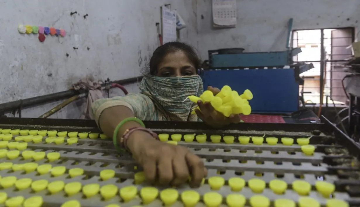 Seorang pekerja membuat lilin jelang Diwali atau Festival Cahaya di Ahmedabad, India, 25 Oktober 2021. Diwali adalah salah satu festival besar yang dirayakan oleh umat Hindu, Jain, Sikh dan beberapa umat Buddha, terutama umat Buddha Newar. (SAM PANTHAKY/AFP)