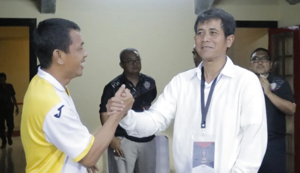 Sebelum pertandingan, pelatih Mitra Kukar, Jafri Sastra, dan pelatih Arema Cronus, Joko Susilo, berbincang akrab. (Bola.com/Erwin Fitriansyah)