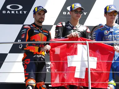 (ki-ka) posisi kedua pembalap KTM Miguel Oliveira, posisi pertama pembalap Yamaha Fabio Quartararo, dan posisi ketiga pembalap Suzuki Joan Mir memegang bendera Swiss untuk menghormati Jason Dupasquier pada MotoGP di Sirkuit Mugello, Scarperia, Italia, Minggu (30/5/2021). (AP Photo/Antonio Calanni)