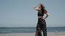 Berlibur ke pantai, aktris kelahiran 1995 ini mengenakan satu set atasan dan celana bermotif yang didominasi warna hitam. (Liputan6.com/IG/@yukikt)