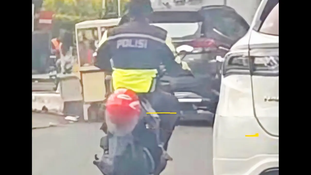 Pria berjaket polisi mengendarai sepeda motor matik tanpa mengenakan helm