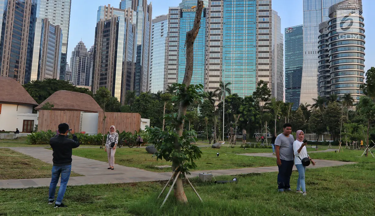 Warga berfoto di Hutan Kota kawasan Gelora Bung Karno, Jakarta, Minggu (6/1). Hutan Kota dapat menjadi pilihan tepat untuk menghabiskan akhir pekan bersama keluarga. (Liputan6.com/JohanTallo)