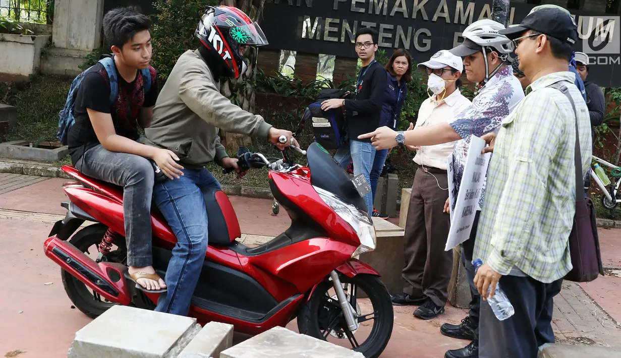 Aktivis Koalisi Pejalan Kaki (KPK) menghadang pengendara sepeda motor yang menerobos trotoar di depan Tempat Pemakaman Umum (TPU) Menteng Pulo, Jalan Casablanca, Jakarta Selatan, Jumat (21/7). (Liputan6.com/ Immanuel Antonius)