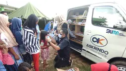 Di posko tersebut PT Asuransi Kredit Indonesia atau Askrindo menghadirkan Mobil Pintar (MoPi) menghibur anak-anak korban banjir dan memberikan bantuan sembako, makanan bergizi, serta buku cerita dan buku gambar. di dua lokasi berbeda di Karawang. (Liputan6.com/Pool/Askrindo)