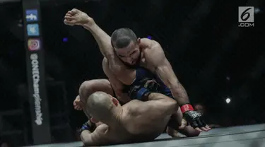 Petarung Rusia, Yusup Saadulaev (bawah) dan petarung Jepang, Masakazu Imanari saling menyerang pada pertarungan One Championship di Jakarta Convention Center (JCC), Sabtu (20/1). Pertarungan dimenangkan oleh Yusup Saadulaev. (Liputan6.com/Faizal Fanani)