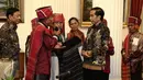 Pemangku Hutan Adat dari Tombak Haminjon (Kemenyan) Provinsi Sumatera Utara saat memberikan kain ulos kepada Presiden Joko Widodo (Jokowi) usai pencanangan pengakuan Hutan Adat di Istana Negara, Jakarta, Jumat (30/12). (Liputan6.com/Faizal Fanani)