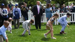 Presiden AS Donald Trump dan Ibu Negara Melania Trump menyaksikan anak-anak menggelindingkan telur paskah di halaman Gedung Putih, Washington, Senin (22/4). Acara tahunan itu merupakan bagian dari rangkaian memperingati Paskah yang rutin diselenggarakan di South Lawn Gedung Putih. (Jim WATSON / AFP)