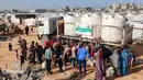 Hal ini diungkap Badan Kemanusiaan Perserikatan Bangsa-Bangsa (PBB) pada Selasa (9/2/2026). Tampak dalam foto, warga mengisi wadah air dari tangki air portabel di kamp pengungsi Palestina Maghazi, Jalur Gaza tengah pada Rabu 11 Februari 2026. (Eyad BABA/AFP)