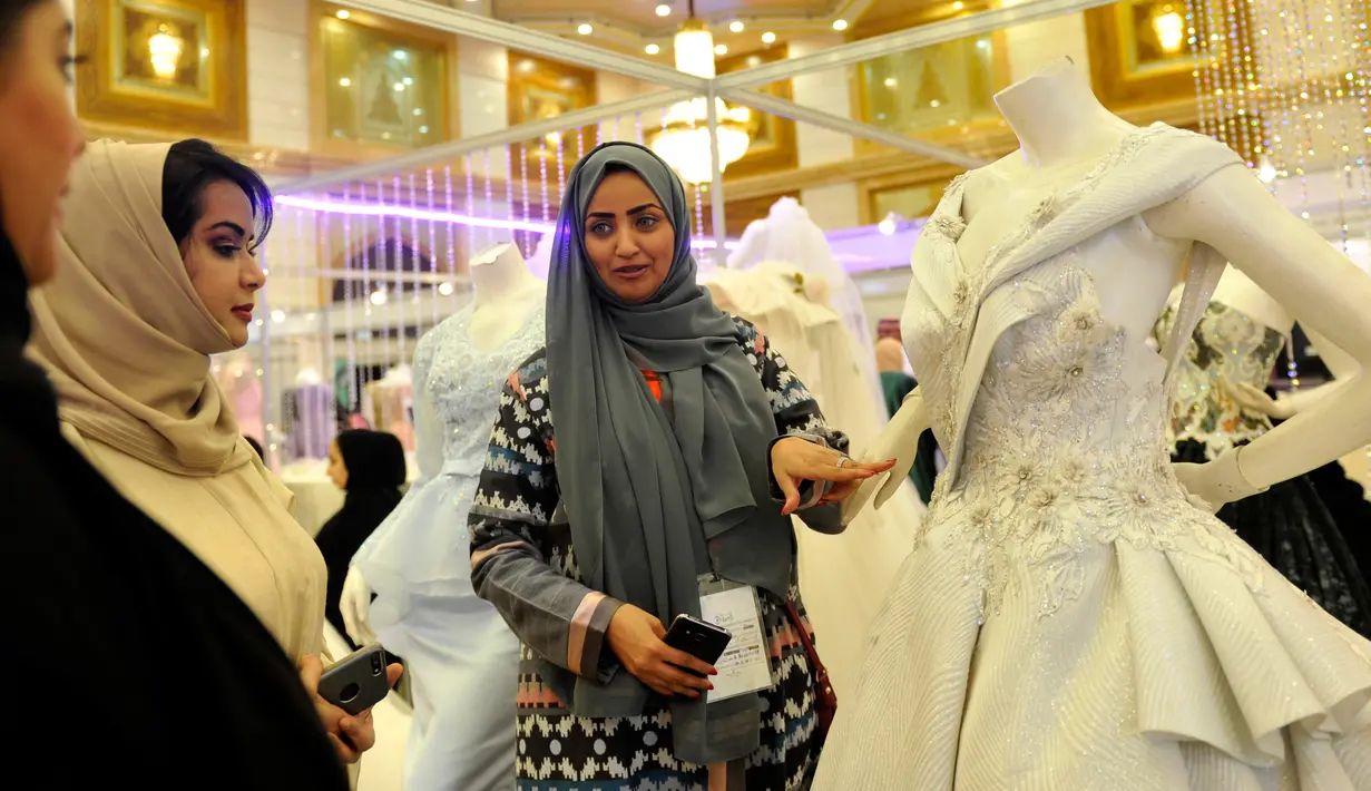Pengunjung melihat gaun pengantin saat berada di pameran pernikahan di Kota Laut Merah, Jeddah, Arab Saudi (11/4). (AFP PHOTO/Amer HILABI)