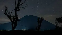 Pemandangan malam Gunung Agung di bawah langit penuh bintang terlihat dari Kubu di Karangasem, Bali, (28/9). Pihak berwenang berencana mengalihkan penerbangan jika terjadi erupsi Gunung Agung. (AFP Photo/Bay Ismoyo)