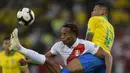 Gelandang Peru, Andre Carrillo, berebut bola dengan bek Brasil, Alex Sandro, pada laga final Copa America 2019 di Stadion Maracana, Rio de Janeiro, Minggu (7/7). Brasil menang 3-1 atas Peru. (AFP/Juan Mabromata)