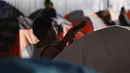 Seorang anak imigran bermain di luar tenda tempat penampungan di Tijuana, Meksiko 6 April 2019. Rombongan migran Amerika Tengah mencapai kota perbatasan antara Meksiko dan AS tersebut  untuk mencari suaka akibat kekerasan, pembunuhan dan kemiskinan yang mengancam mereka. (REUTERS/Carlos Jasso)
