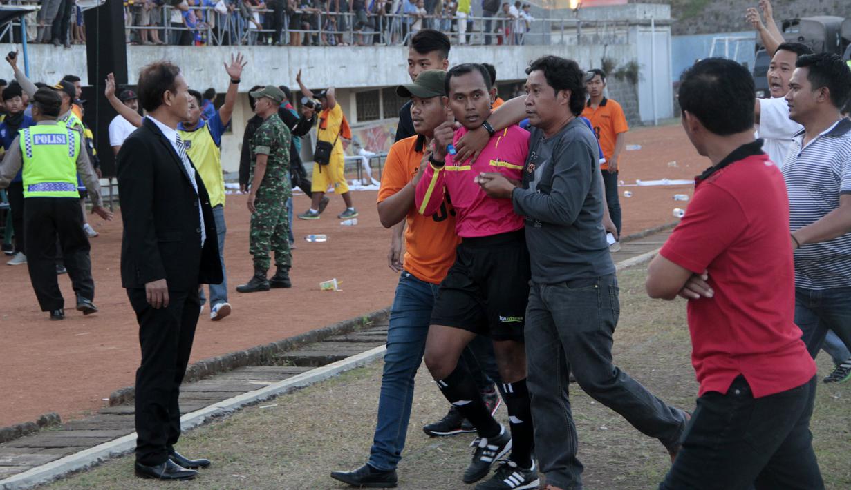 Wasit Maulana diamankan petugas keamanan  setelah final lanjutan Piala Polda Jateng di Stadion Jatidiri, Semarang, Minggu (2/8/2015). (Bola.com/Vincensius Sawarno)