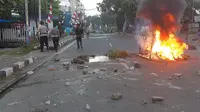 Massa turun ke jalan dalam unjuk rasa yang berujung kerusuhan di Manokwari, Papua, Senin (19/8/2019). Mereka membakar gedung DPR juga memblokade jalan dengan membakar ban sebagai buntut dari peristiwa yang dialami mahasiswa Papua di Surabaya dan Malang, serta Semarang beberapa hari lalu. (STR / AFP)