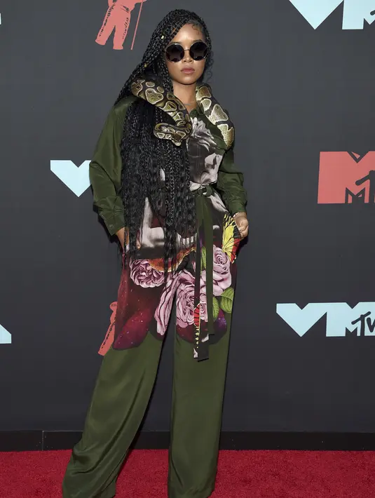 H.E.R. berpose saat menghadiri MTV VMA's 2019 di New Jersey, AS (26/8/2019).  H.E.R. tampil membawa ular di lehernya sebagai aksesoris dan mendapatkan pujian dari netizen. (Photo by Charles Sykes/Invision/AP)
