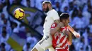 Striker Real Madrid, Karim Benzema, berebut bola dengan bek Girona, Juanpe Ramirez, pada laga La Liga di Stadion Santiago Bernabeu, Madrid, Minggu (17/2). Madrid kalah 1-2 dari Girona. (AFP/Gabriel Bouys)