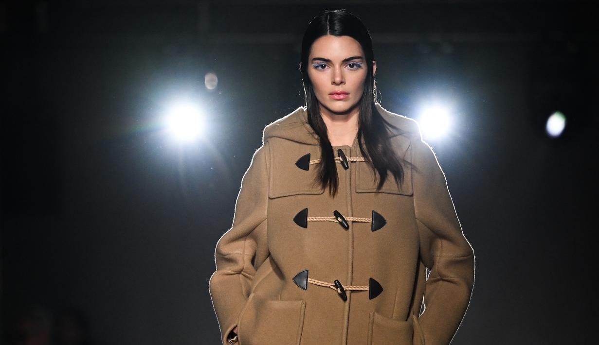 Kendall Jenner mempersembahkan kreasi Prada selama Koleksi Wanita Musim Gugur-Musim Dingin 2023-2024 sebagai bagian dari Fashion Week di Milan pada 23 Februari 2023. Kendall 27 tahun terlihat sangat luar biasa saat dia keluar dengan mengenakan mantel ransel unta. Mantel itu terbuka di bagian bawah untuk melihat sekilas kaki telanjang dan panjang bintang realitas itu. (AFP/Marco Bertorello)