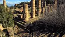 Seorang pria menuruni tangga di situs kota Yunani kuno Kirene di pinggiran kota Shehhat, Libya (13/12/2019). Kota tua Yunani ini menjadi bagian dari imperium yang dikuasai oleh Dinasti Ptolemeus dari Alexandria di Mesir dan jatuh ke tangan Kekaisaran Romawi.  (AFP/Abdullah Doma)