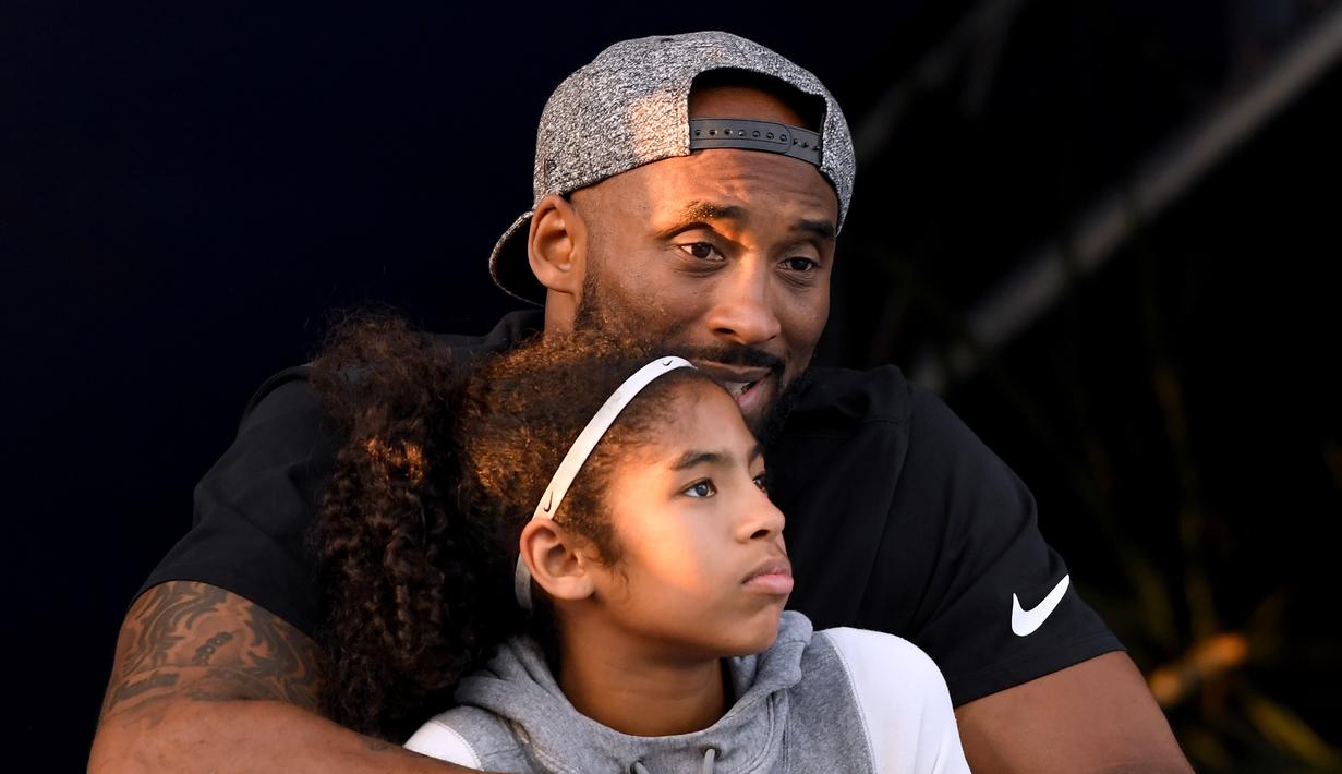 Mantan pebasket LA Lakers, Kobe Bryant, bersama putrinya Gianna menyaksikan Kejuaraan Renang Nasional di Woollett Aquatics Center, Jumat (26/7/2018). (AFP/Harry How)