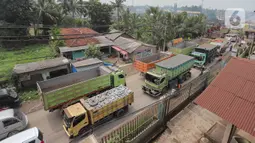 Truk-truk itu diparkir di jalan, memblokade lalu lintas, dan membuat warga sulit melintas. (merdeka.com/Arie Basuki)