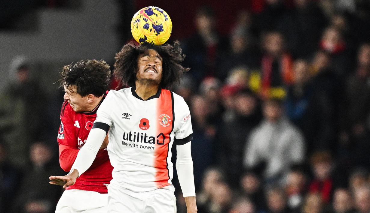 Pemain Manchester United, Victor Lindelof, duel udara dengan pemain Luton Town, Tahith Chong, pada pekan ke-12 Premier League 2023/2024 di Stadion Old Trafford, Sabtu, (11/11/2023). Berkat hasil ini, Manchester United naik ke peringkat enam klasemen sementara EPL 2023/2024. (AFP/Oli Scarff)