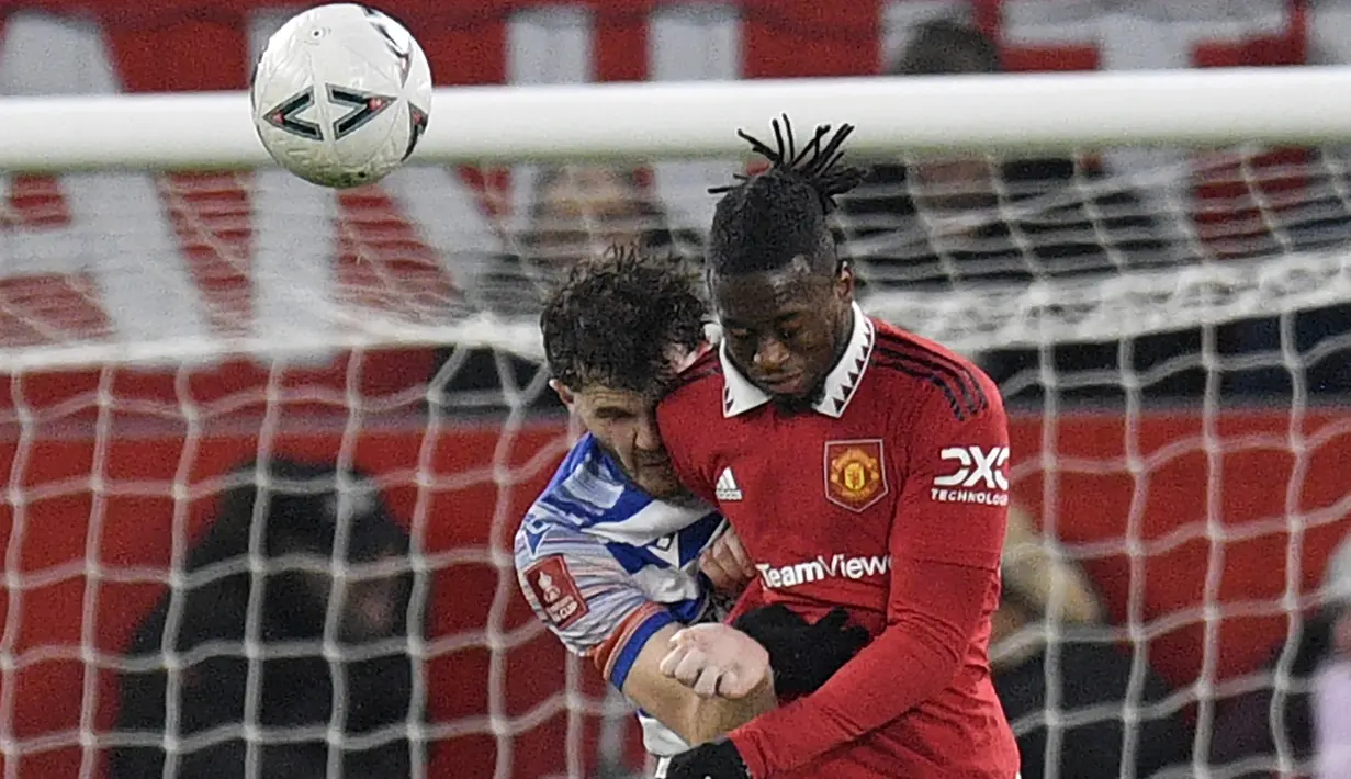 Bek Manchester United, Aaron Wan-Bissaka (kanan) berduel udara dengan bek Reading, Tom Holmes pada laga putaran keempat Piala FA 2022/2023 di Old Trafford Stadium, Manchester (28/1/2023). Aaron Wan-Bissaka didatangkan MU dari Crystal Palace pada awal musim 2019/2020 dengan nilai transfer 55 juta euro. Lama menjadi andalan di posisi bek kanan, posisinya sempat direbut Diogo Dalot, namun akhirnya ia kembali jadi pilihan utama. Hingga kini ia telah tampil dalam 160 laga di semua ajang dengan torehan 2 gol dan 11 assist. (AFP/Oli Scarff)
